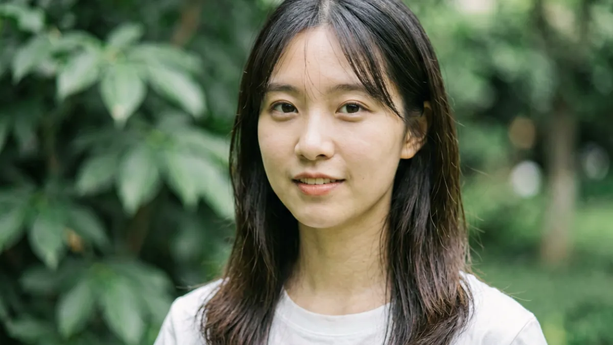 桥本香菜在户外自然光线下拍摄的写真风格照片，背景是柔和绿意，气质清新自然不加修饰